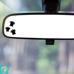 May include: A rearview mirror with three black turtle silhouettes on the top left corner of the mirror.
