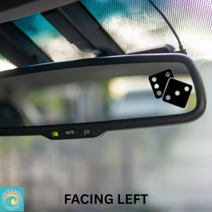 May include: A car rearview mirror with two black dice stickers. The dice show a six and a five. The text "FACING LEFT" is at the bottom of the image.