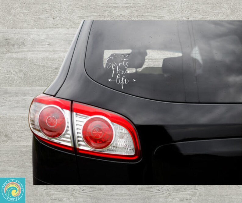 May include: A black car with a white vinyl decal on the back window that reads "I'm that Sports Mom - life".
