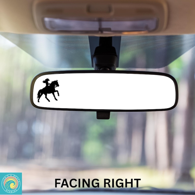 Pu&ograve; includere: Una silhouette nera di una persona a cavallo rivolta a destra, &egrave; mostrata su uno specchietto retrovisore in un'auto. Lo specchietto &egrave; appeso al soffitto dell'auto. Lo sfondo &egrave; sfocato e mostra alberi.