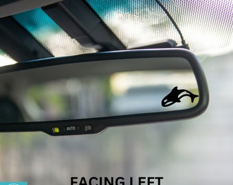 May include: A black orca whale silhouette decal facing left, reflected in a rearview mirror of a car. The mirror has an "AUTO" button.