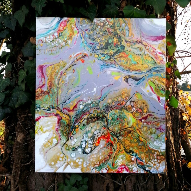 Puede incluir: Pintura abstracta sobre lienzo con colores que se arremolinan en blanco, dorado, verde, azul y rojo. La pintura tiene una superficie texturizada con peque&ntilde;as formas redondas.