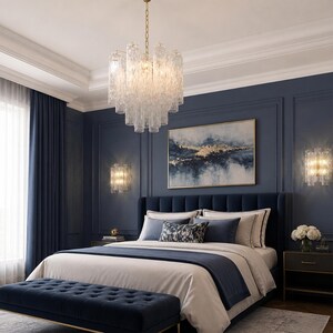 a luxurious bedroom with a large bed, a chandelier, and a painting on the wall. The room has a dark blue color scheme, and the bed is adorned with white linens and blue and white pillows. The chandelier is hanging from the ceiling, and the painting on the wall adds an artistic touch to the room.