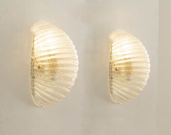 Set van 2 schelpenwandkandelaars van kristalkleurig Muranoglas met messing structuur, Made in Italy