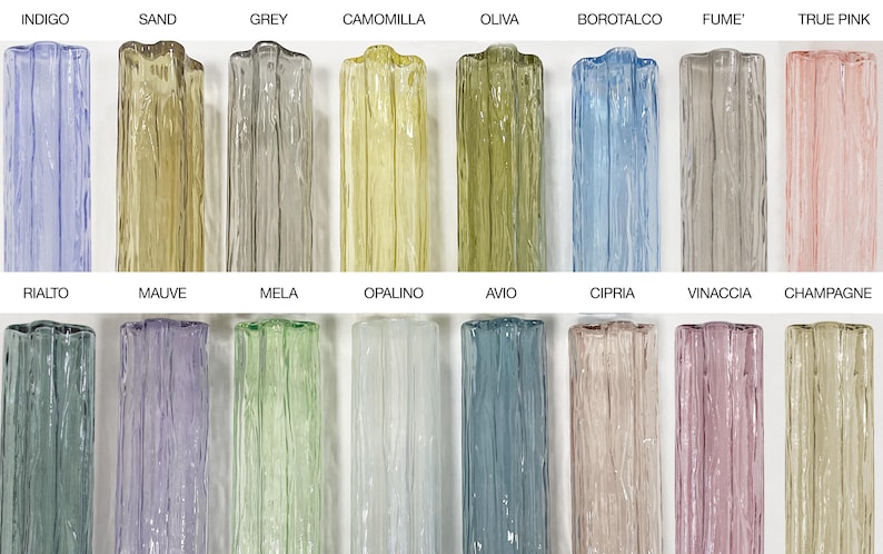 a collection of twelve glass vases, each with a unique color and pattern, arranged in two rows of six. The vases are labeled with their names, such as Indigo, Sand, Grey, Camomilla, Olive, Borotalco, Fume, True Pink, Ralto, Malve, Mela, Opalino, Avio, Cipri, Vinacia, and Champagne.