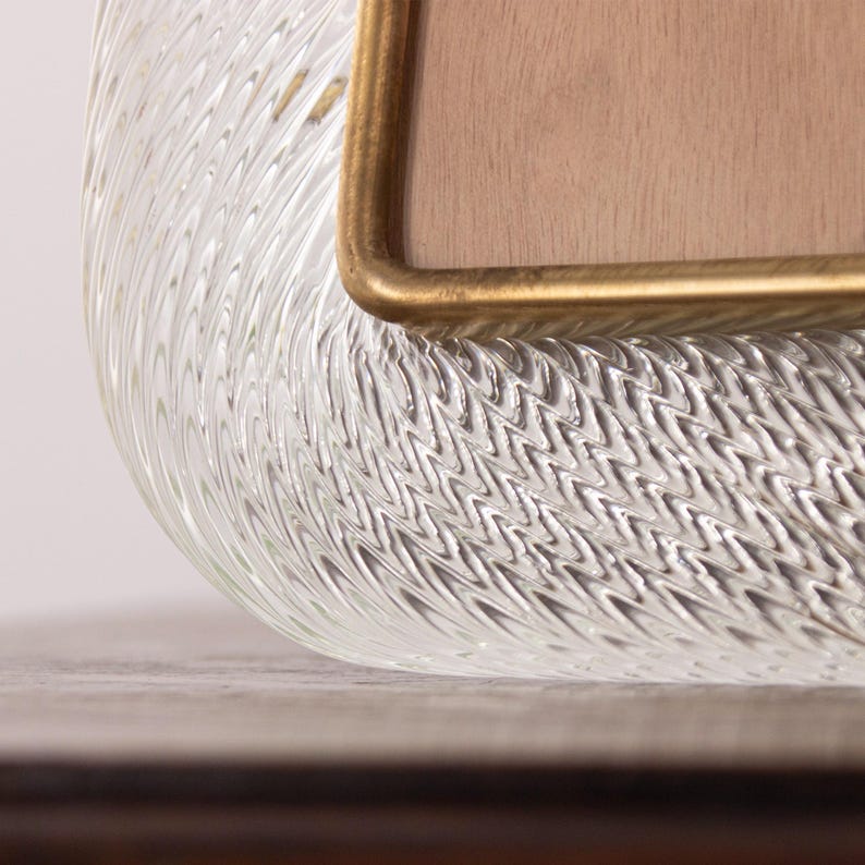 May include: Close-up of a clear glass tray with a textured surface. The tray has a gold-colored metal trim around the edge.