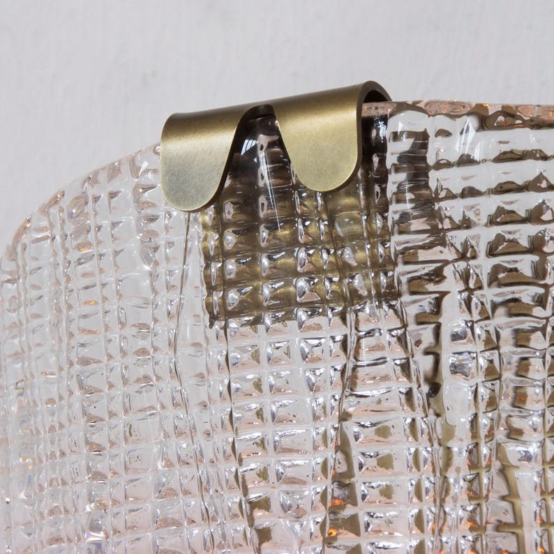 a close-up view of a clear glass surface with a metallic, curved piece attached to it.