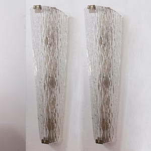 two tall, thin, and metallic wall sconces with a textured, woven design.