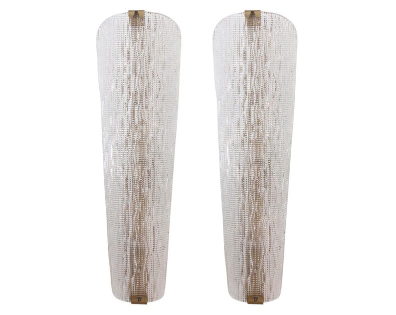 two tall, clear glass lamps with a textured, woven pattern.