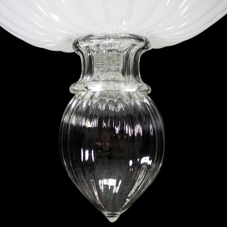 A close-up view of a clear glass vase or container with a ribbed texture, set against a black background.