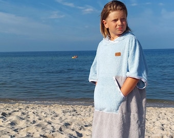 May include: A light blue and gray hooded towel with a pocket. The towel is made of soft, absorbent material and is perfect for drying off after a swim or a day at the beach.