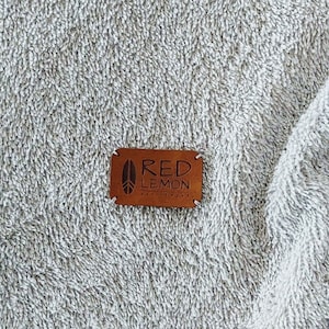 May include: A brown leather patch with the text "RED LEMON ACTIVEWEAR" in white lettering.