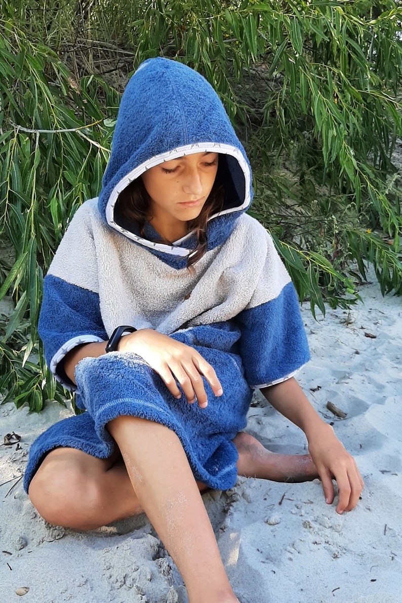 May include: A blue and white hooded towel with a white trim. The towel is made of soft, absorbent material and is perfect for drying off after a swim or shower.