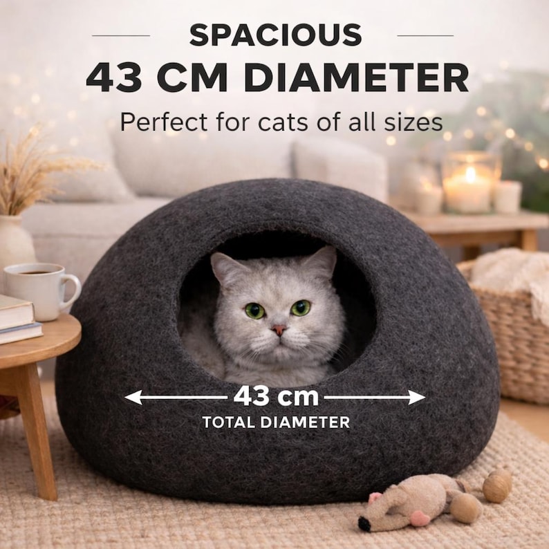 Peut inclure: Une grotte pour chat en feutre gris fonc&eacute; avec une ouverture ronde et un diam&egrave;tre de 43 cm. Le texte sur l'image indique : SPACIOUS 43 CM DIAMETER, Perfect for cats of all sizes, et 43 cm TOTAL DIAMETER. Un chat clair est visible &agrave; l'int&eacute;rieur.
