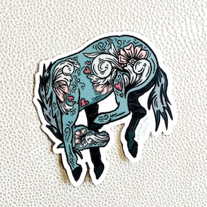 May include: A blue and white floral patterned sticker of a horse with a black outline. The sticker has the text "Horseshoe Band" and "Curls" on it.