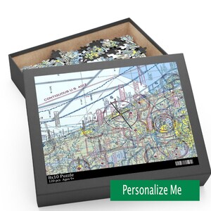 May include: A black box with a 8x10 puzzle inside. The puzzle is a map of the contiguous U.S. ADIZ. The box has a label that says "8x10 Puzzle 120 pcs Ages 9+" and "Personalize Me".