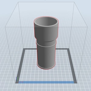 May include: A gray, cylindrical object with a slightly wider top and bottom. The object is standing on a gridded surface.
