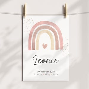 Peut inclure: Un arc-en-ciel aquarelle rose et beige avec un petit c&oelig;ur au centre. Le texte "Leonie" est sous l'arc-en-ciel, suivi de la date "09. Februar 2025", de l'heure "22:18Uhr", du poids "3315g" et de la taille "52cm".