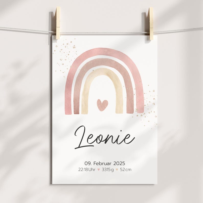 Peut inclure: Un arc-en-ciel aquarelle rose et beige avec un petit c&oelig;ur au centre. Le texte "Leonie" est sous l'arc-en-ciel, suivi de la date "09. Februar 2025", de l'heure "22:18Uhr", du poids "3315g" et de la taille "52cm".