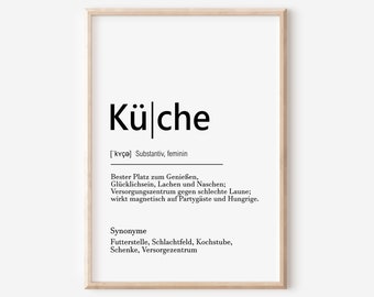May include: A framed print with the German word "Küche" in bold black letters. Below, a definition and synonyms are listed in German. The print has a white background and a light brown wooden frame.
