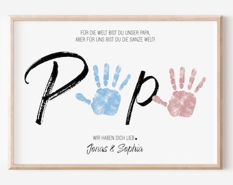 May include: A white background with black text that reads "FÜR DIE WELT BIST DU UNSER PAPA, ABER FÜR UNS BIST DU DIE GANZE WELT!"  The word "Papa" is written in large black script with two handprints, one blue and one pink, in the middle of the word.  The text "WIR HABEN DICH LIEB" is written in black script below the handprints.  The names "Jonas & Sophia" are written in black script below the text.