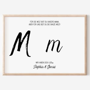 Puede incluir: Una impresi&oacute;n enmarcada con fondo blanco presenta el texto "F&Uuml;R DIE WELT BIST DU UNSERE MAMA, ABER F&Uuml;R UNS BIST DU DIE GANZE WELT!" y "WIR HABEN DICH LIEB." Se muestran dos letras "M" negras en cursiva. Tambi&eacute;n se incluyen los nombres "Sophia & Jonas".