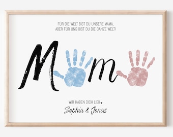 May include: A framed print with the word "Mom" in black script, featuring blue and pink handprints. The print includes German text and the names "Sophia & Jonas" in a cursive font, all on a white background.