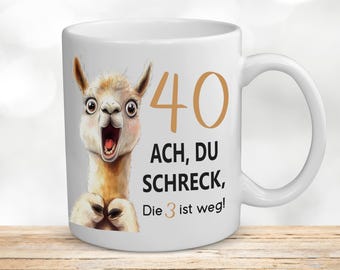 May include: White ceramic mug with a cartoon llama illustration and the text "40 ACH, DU SCHRECK, Die 3 ist weg!"