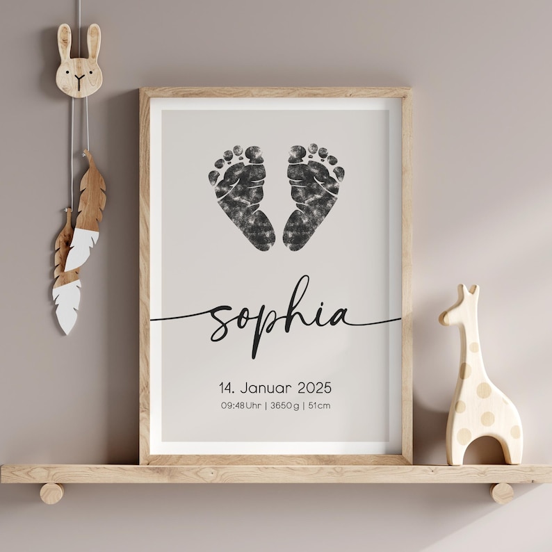 Peut inclure: Une impression encadr&eacute;e avec des empreintes de pieds d'encre noire en forme de c&oelig;ur. Le nom "Sophia" est &eacute;crit en cursive sous les empreintes de pieds. La date "14. Januar 2025" et l'heure "09:48 Uhr | 3650g | 51cm" sont imprim&eacute;es sous le nom.