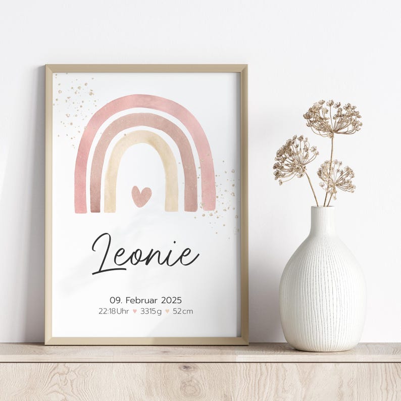 Peut inclure: Un arc-en-ciel aquarelle rose, beige et blanc avec un petit c&oelig;ur au centre. Le texte "Leonie" est sous l'arc-en-ciel, suivi de la date "09. Februar 2025", de l'heure "22:18Uhr", du poids "3315g" et de la taille "52cm".