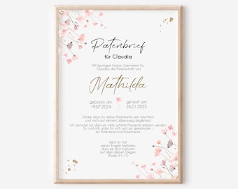 May include: A framed print with a light wood frame. The print has a white background with delicate pink floral accents. The text is in black and gold script, including the name "Mathilda" and dates. The print is a baptism or christening announcement.