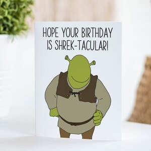 K&ouml;nnte beinhalten: Eine gr&uuml;ne Gru&szlig;karte mit einem Cartoon-Bild von Shrek aus dem Film Shrek. Die Karte lautet "Ich hoffe, dein Geburtstag ist Shrek-takul&auml;r!"