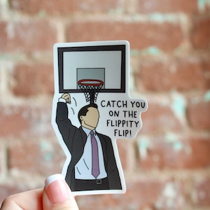 May include: A white sticker with a cartoon illustration of a person in a suit making a basketball shot. The text on the sticker reads "Catch you on the flippity flip!"