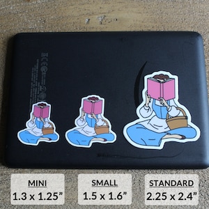 May include: Three different sizes of a sticker featuring a cartoon illustration of a woman sitting with a book covering her face. The sticker is available in mini, small, and standard sizes. The mini sticker is 1.3 inches by 1.25 inches. The small sticker is 1.5 inches by 1.6 inches. The standard sticker is 2.25 inches by 2.4 inches.
