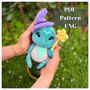 Puede incluir: Patrón de crochet para una linda bruja de color turquesa con un sombrero morado y una varita amarilla. El patrón está disponible en formato PDF y está escrito en inglés.  PDF Pattern ENG