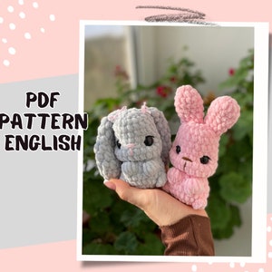 Peut inclure: Un patron PDF pour crocheter deux peluches de lapin. Un lapin est gris et l'autre est rose. Le patron est écrit en anglais.