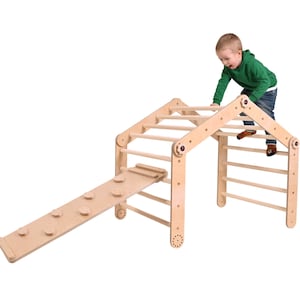 May include: A wooden climbing structure for children, featuring a triangular frame with a roof, a ladder, and a slide. A child is climbing on the structure.