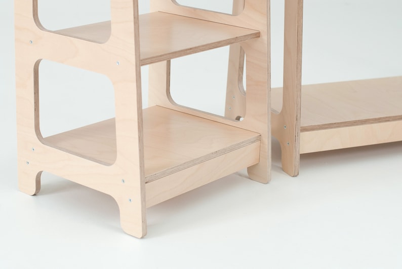 Op de afbeelding: Een houten opstapje met drie planken. De opstap is gemaakt van licht hout en heeft een eenvoudig ontwerp.