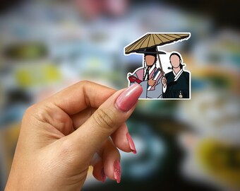 May include: A sticker featuring a stylized illustration of two figures in traditional Korean attire. One figure holds a parasol, while the other holds a long pipe. The figures are depicted with simplified facial features and are outlined in black.