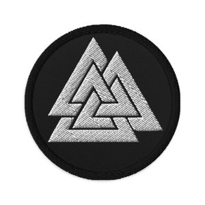 Könnte beinhalten: Ein gestickter Patch in Schwarz und Weiß mit einem runden Design und einem weißen Valknut-Symbol in der Mitte. Der Valknut ist ein Symbol der nordischen Mythologie und wird oft mit Odin in Verbindung gebracht.