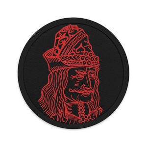 Può includere: Toppa ricamata rossa di Vlad l'Impalatore, una figura storica, su uno sfondo circolare nero.