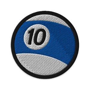 May include: Embroidered patch featuring a blue and white design resembling a billiard ball. The number 10 is prominently displayed in black within a white circle. The patch has a black border.