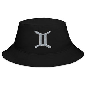 Puede incluir: Sombrero de pescador negro con un símbolo de Géminis del zodíaco bordado en plata.