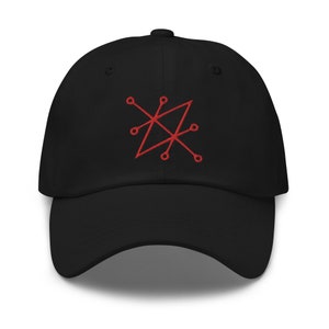 Op de afbeelding: Zwarte baseballpet met een rood geborduurd geometrisch ontwerp.