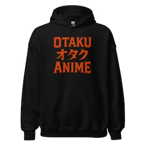 以下が含まれることがあります： 黒色のフード付きスウェットシャツ。オレンジ色のブロック体で「OTAKU」の文字が日本語の文字の上に、オレンジ色のブロック体で「ANIME」の文字がプリントされています。スウェットシャツには、ドローストリングフードとカンガルーポケットが付いています。
