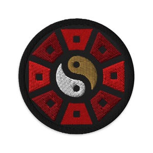 May include: A black and red embroidered patch with a yin yang symbol in the center. The yin yang symbol is white and gold. The patch is circular and has a black border.