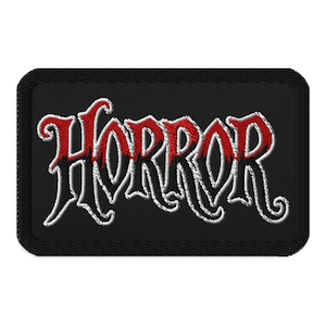 May include: Black rectangular patch with the word "HORROR" embroidered in a gothic font. The letters are outlined in white with red shading, set against a black background.