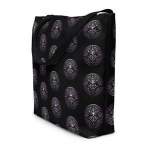 May include: Black tote bag with a repeating pattern of silver-colored eye symbols. The bag has a black shoulder strap and is made of a durable material. The design is a repeating pattern of an eye within a decorative oval.