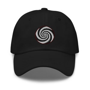 May include: Black baseball cap with a white and black spiral design embroidered on the front.