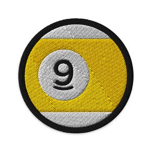 May include: Circular embroidered patch depicting a nine-ball design. The patch has a black border, with a yellow and white design. The number 9 is in black, centered on a white circle, with a yellow background.